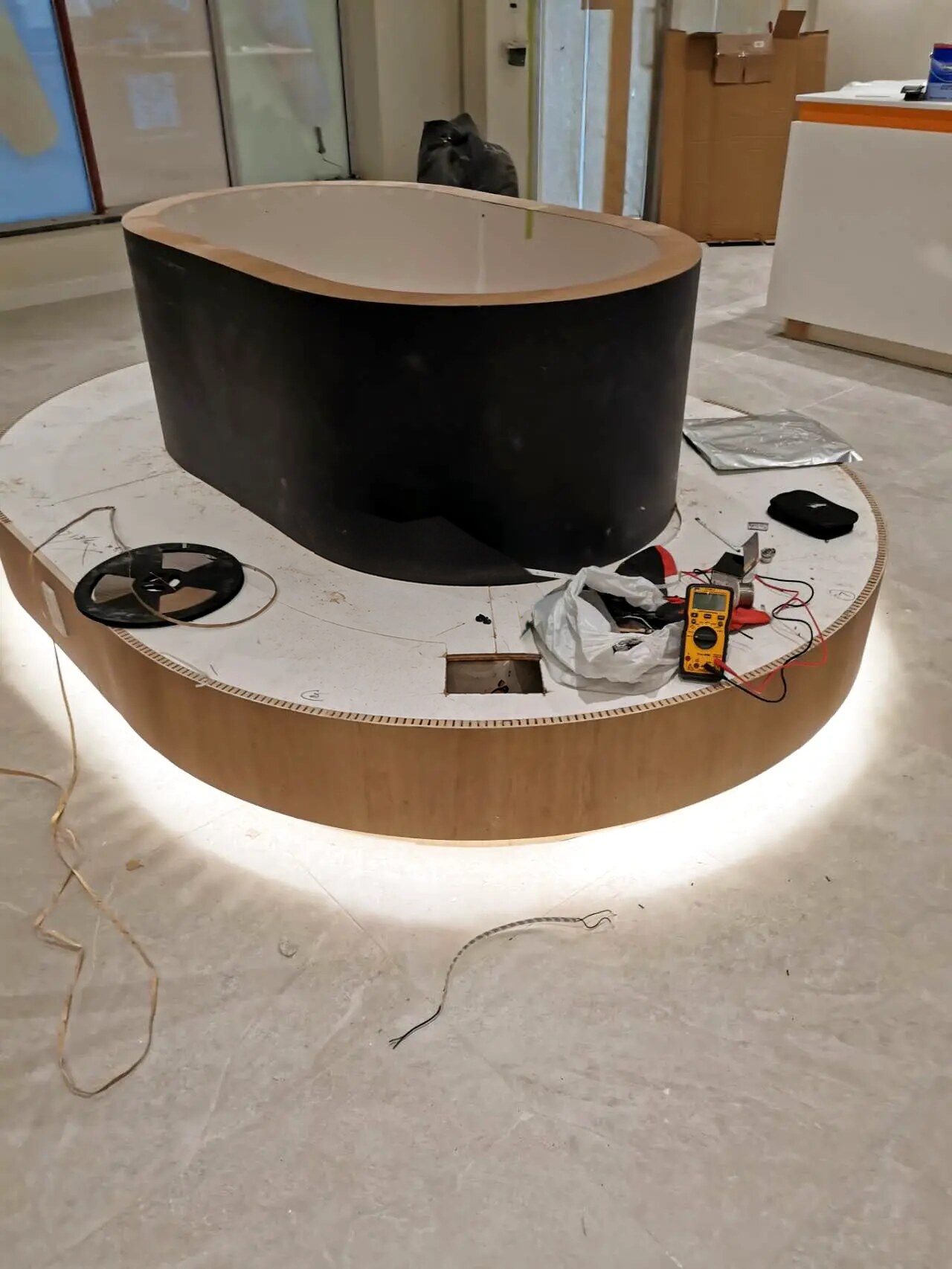 Custom oval commercial island with integrated lighting during construction