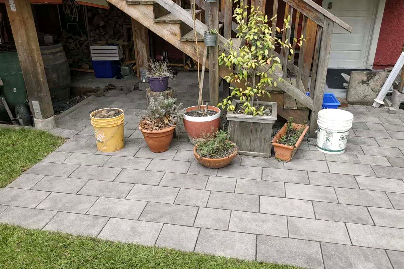 Residential paver surface beside an existing wood deck