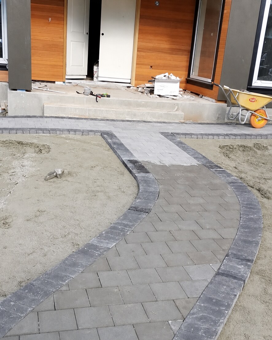 Curved residential paver walkway being installed at a front entrance